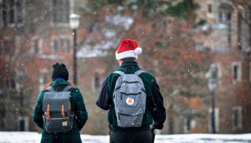 Students walk across Ho Plaza as a light snow falls.