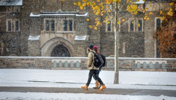 Students pass Myron Taylor Hall as November snow hangs in the air.