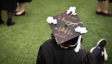 Graduate cap with "We will never be this young again so full of fire and rebellion Cornell 2021"
