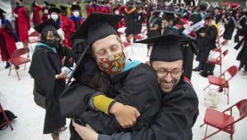 Graduates hug.