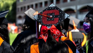 A graduation cap decorated with a red C. 