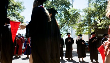 Faculty wave to graduates as they walk to the ceremony. 