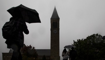 Students walk through campus on a rainy afternoon.