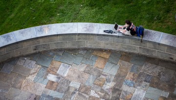 A student works at the base of McGraw Clocktower.