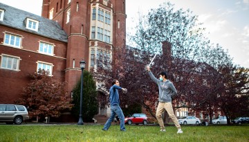 Students practice fencing in front of Risley Hall.