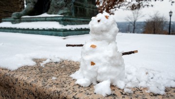 A snowman befriends the Ezra Cornell statue on the Arts Quad.