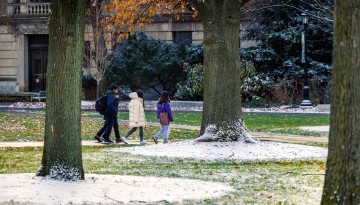 Students traverse a light blanket of snow on the Ag Quad.