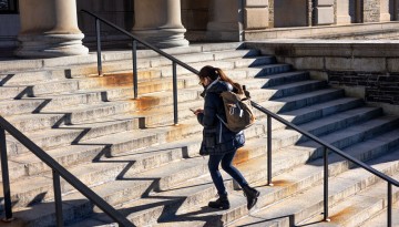 A student ascends the steps of Baker Lab.