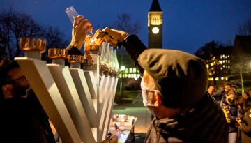A menorah is lit in front of Willard Straight Hall.