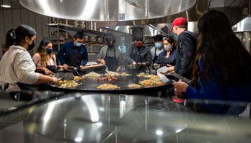 Members of the Meinig Family Cornell National Scholars Mentor Group make dinner around the grill in Morrison Dining Hall.