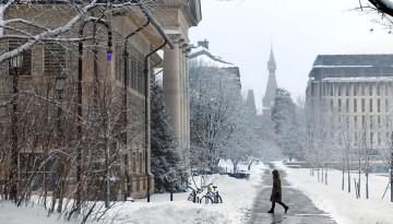 A person walks on a snow covered Arts Quad following a winter storm.