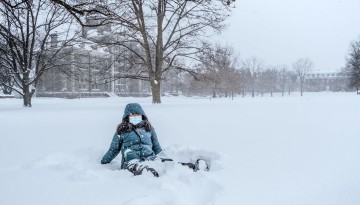 A student enjoys the snow on the Arts Quad.