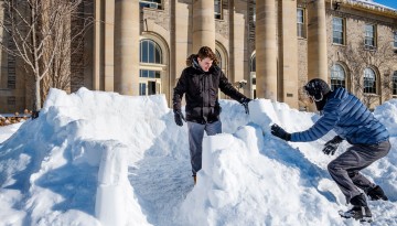 Students build a snow fort in front of Goldwin Smith Hall.