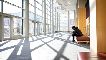 A student works in the morning sun in Statler Hall.