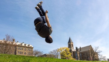 A student tumbles down Libe Slope during a break between classes.