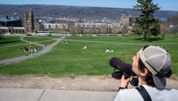 A member of the Cornell Birding Club looks for birds on Libe Slope.