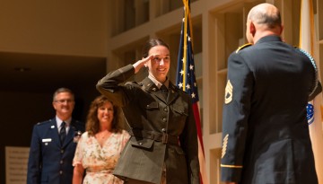 An ROTC graduate saluting.