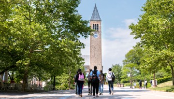 Cornell summer students walk through a sunny Ho Plaza towards McGraw Tower. 