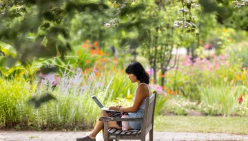 Student on laptop in garden