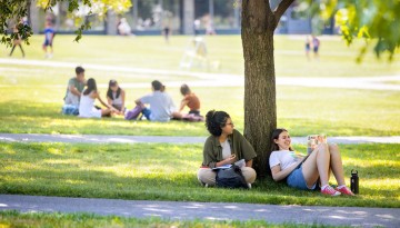 Students work in the shade of the Arts Quad on a warm late summer day.