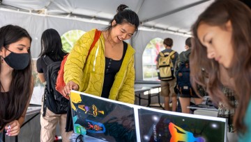Students look at and buy posters for their dorms at the beginning of term poster sale on Ho Plaza. 