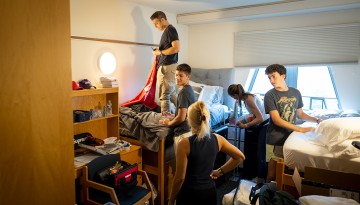 A family of five helps set up a dorm room. 