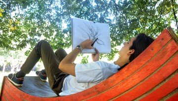 A student draws for an art class on the Arts Quad.