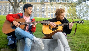 Students play guitar on Libe Slope.