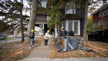 Students in the College of Architecture, Art and Planning work on deconstructing a home in Collegetown as part of a class with professor Felix Heisel.