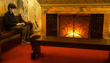 A student studies by the glow of a fireplace in Uris Library.
