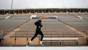 A student-athlete training at Schoellkopf Field in the winter.