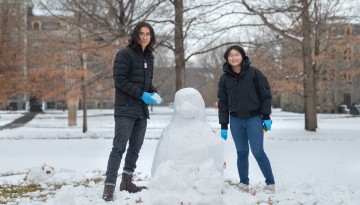 Students build a snow penguin on the Arts Quad.