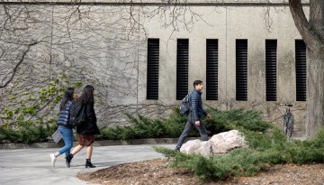 Students walk past Uris Hall between classes.