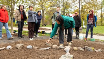 Students from Cornell Botanic Gardens’ Learning by Leading program and the American Indian and Indigenous Studies program plant the “Full Circle Healing and Honoring Garden” in front of Akwe:kon.