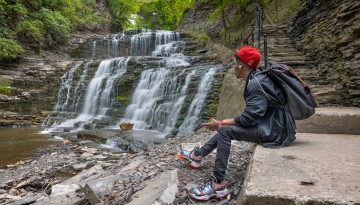 An engineering student enjoys a quiet moment in Cascadilla Gorge.