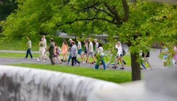 Prospective students and families take a summer tour of campus through the Arts Quad.