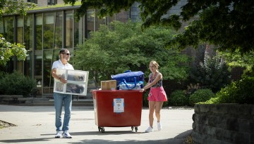 A father and daughter moving belongings to a dorm. 