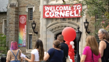 A "Welcome to Cornell" banner hangs on the entrance to Willard Straight Hall. 