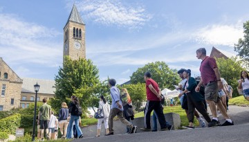 New students and families walk along Ho Plaza towards McGraw Tower. 
