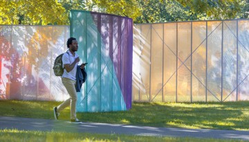A student passes by the “School's Out” installation on the Arts Quad.