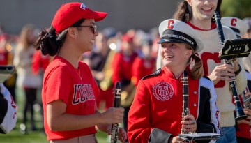 Big Red Band members share a moment of laughter during the halftime show, Homecoming Weekend 2023 at Schoellkopf Stadium.
