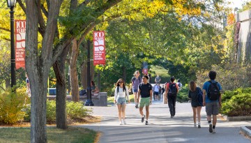 Students walk past Peter Plaza on a warm fall day.