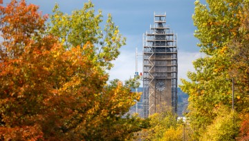 Enshrouded in scaffolding, McGraw Tower peeks through the fall leaves along Tower Road.