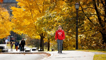 Students walk along the top of Libe Slope on a warm fall afternoon.