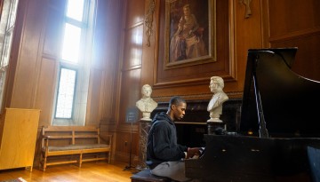 A student plays piano in Anabel Taylor Hall.