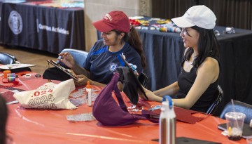 Students decorate their graduation caps during a Senior Days activity at Willard Straight Hall.