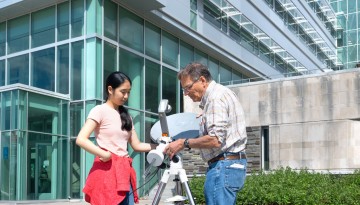 Physics student Ellyn Hu and associate professor Carl Franck take microwave temperature readings of the sun.