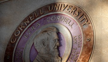The Cornell seal outside Day Hall is lit by the morning sun.