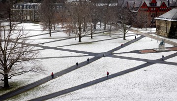 Students cross the Arts Quad covered in light snow.
