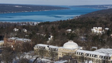 Sibley Hall is seen on a snowy morning with Cayuga Lake in the background.